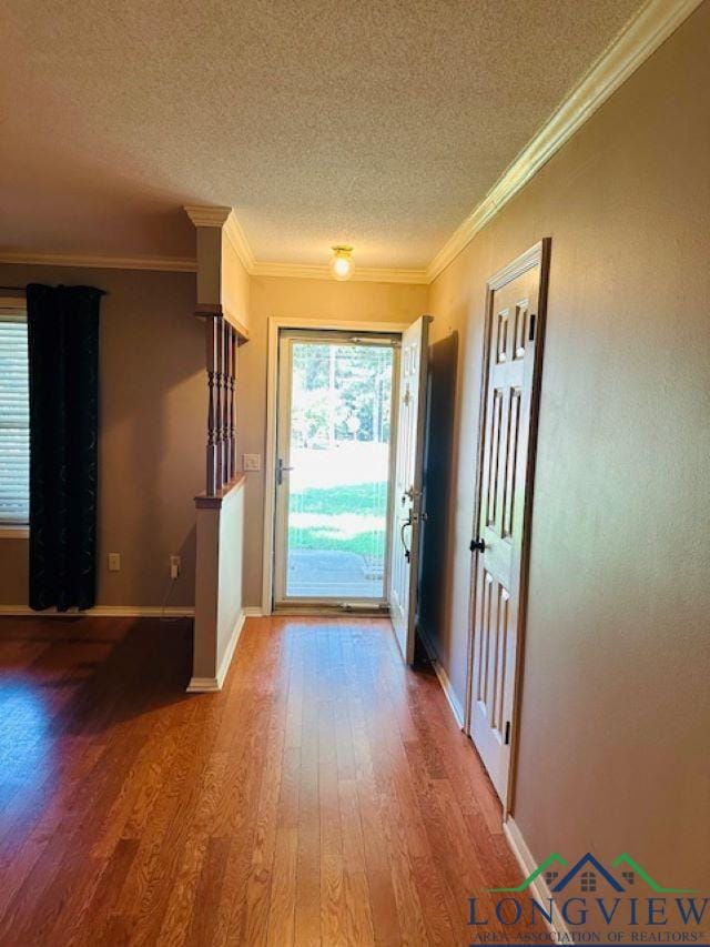 entryway featuring hardwood / wood-style floors, a textured ceiling, and crown molding