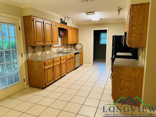 kitchen featuring tasteful backsplash, crown molding, sink, light tile patterned floors, and dishwasher