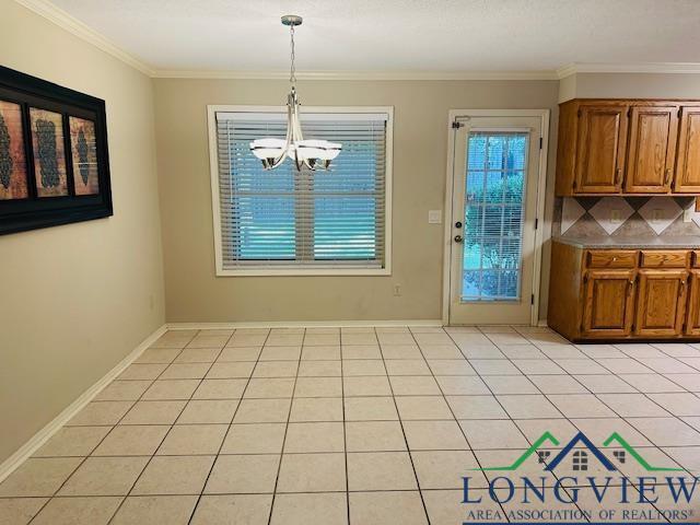 unfurnished dining area with a notable chandelier, light tile patterned floors, and crown molding