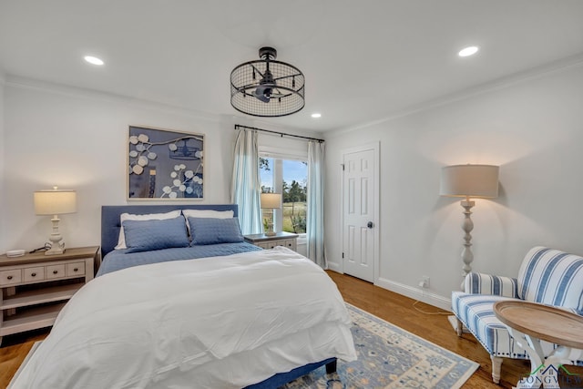 bedroom with ornamental molding, recessed lighting, wood finished floors, and baseboards