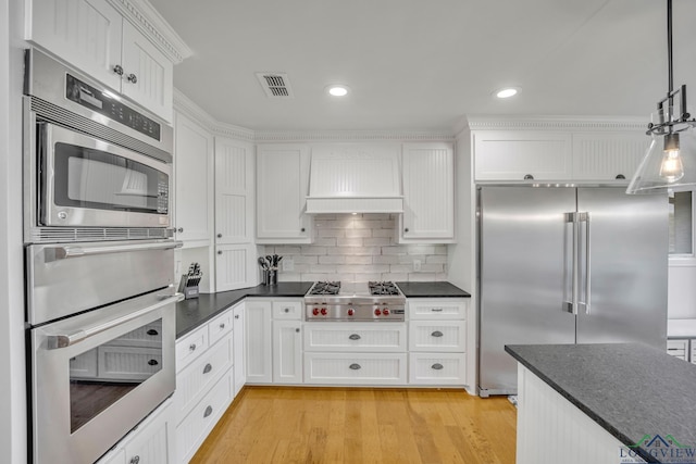 kitchen featuring stainless steel appliances, custom range hood, light wood-style floors, and white cabinetry