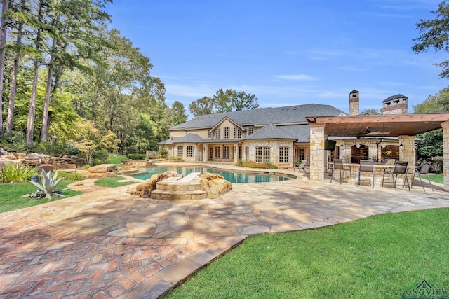 pool featuring a patio, a ceiling fan, outdoor dry bar, french doors, and a lawn