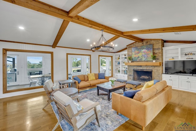 living area featuring vaulted ceiling with beams, a stone fireplace, light wood-style flooring, built in features, and an inviting chandelier