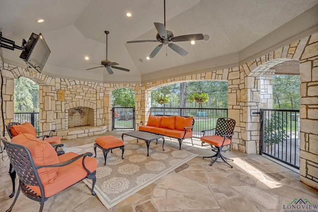 exterior space featuring an outdoor living space with a fireplace and a ceiling fan