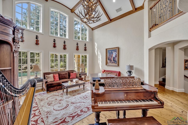 sunroom / solarium with arched walkways, plenty of natural light, visible vents, and a notable chandelier