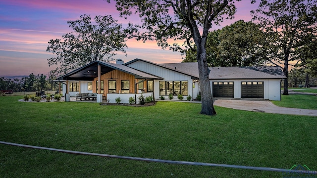 modern farmhouse style home with an attached garage, driveway, a chimney, and a front yard