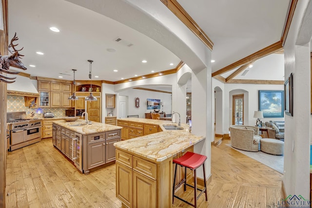 kitchen with open floor plan, range with two ovens, a spacious island, and a kitchen bar