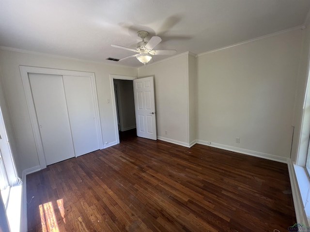 unfurnished bedroom with visible vents, a ceiling fan, a closet, crown molding, and dark wood-style flooring