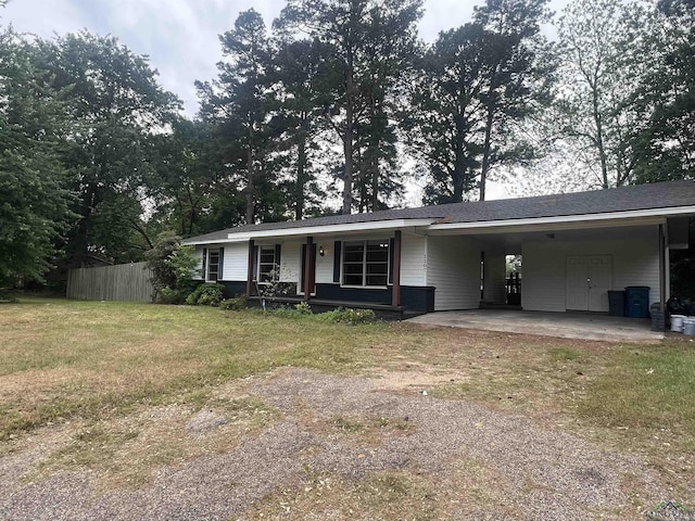 view of front of home featuring a carport, driveway, covered porch, fence, and a front yard