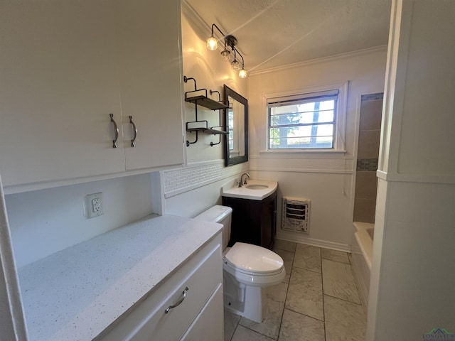 bathroom featuring vaulted ceiling, heating unit, vanity, toilet, and ornamental molding