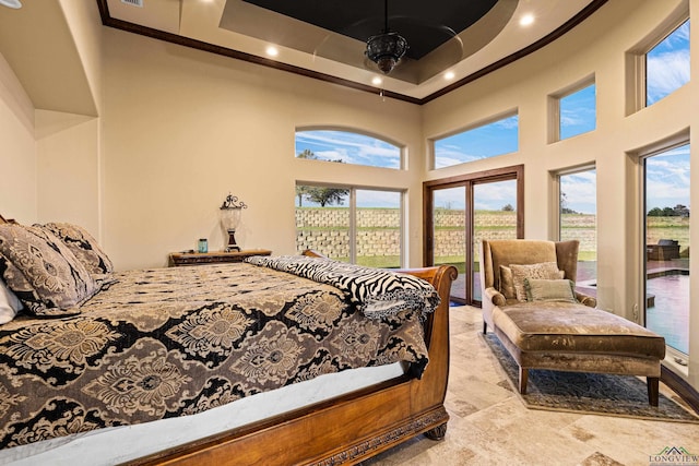 bedroom with a raised ceiling, a towering ceiling, and access to outside