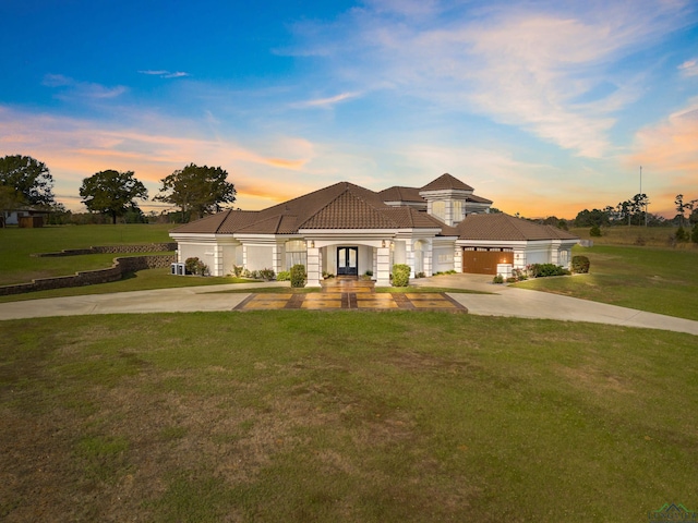 view of front of house featuring a yard and a garage