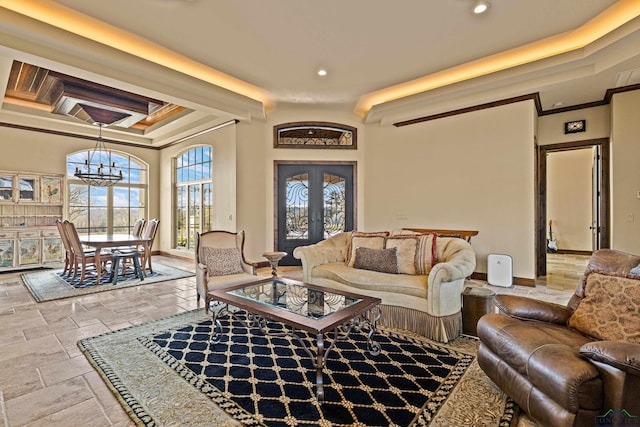 living room featuring french doors, crown molding, and an inviting chandelier