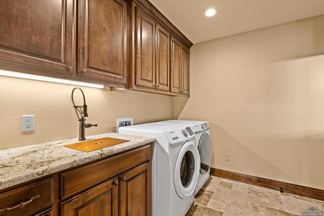 laundry area featuring cabinets, washing machine and dryer, and sink