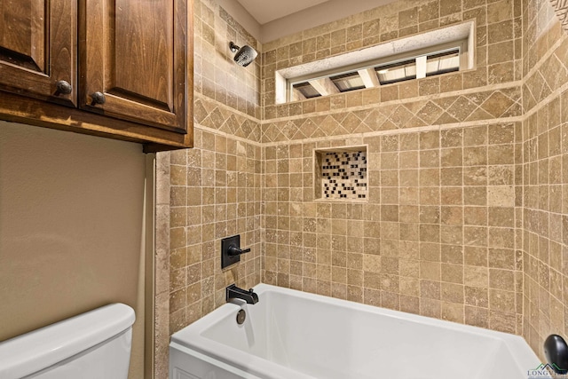 bathroom with tiled shower / bath combo and toilet