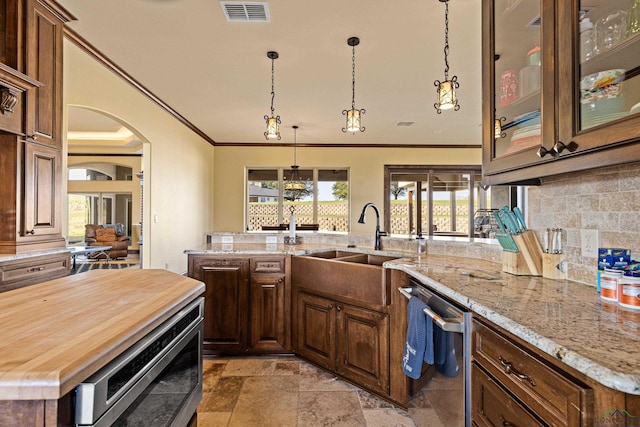 kitchen with dishwasher, a kitchen island, light stone countertops, and sink