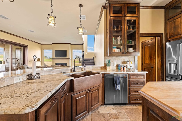 kitchen featuring stainless steel appliances, light stone counters, crown molding, and sink