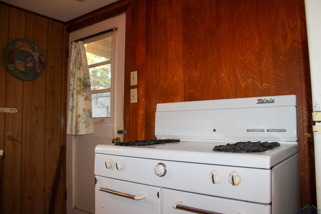 interior space featuring wood walls and white range with gas stovetop