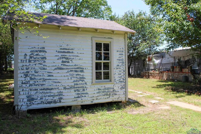 view of property exterior featuring a storage unit and a yard