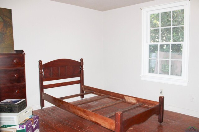 bedroom with dark wood-type flooring