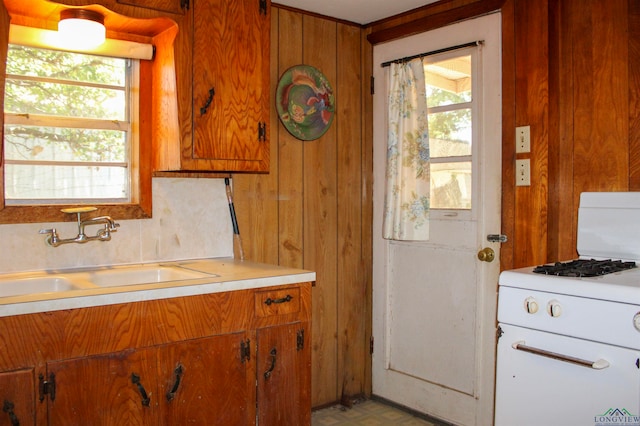 kitchen with decorative backsplash, sink, and white range with gas cooktop