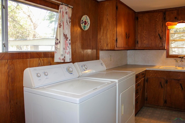 laundry room with cabinets, independent washer and dryer, and sink