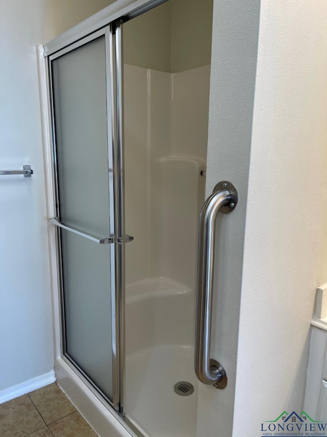 bathroom featuring tile patterned flooring and an enclosed shower