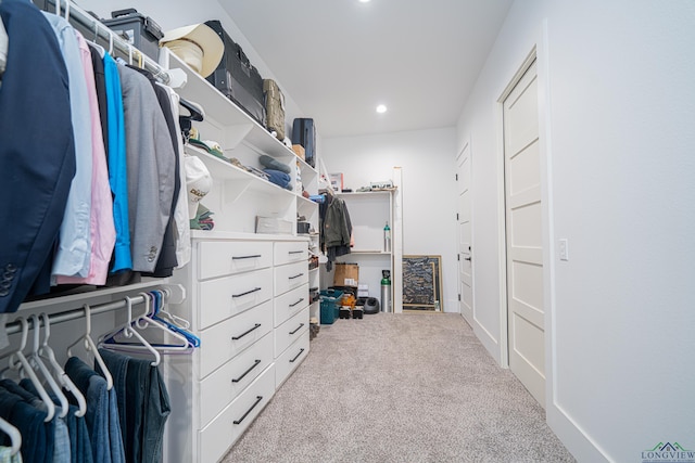 walk in closet featuring light carpet