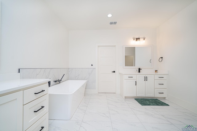 bathroom featuring vanity, tile walls, and a tub