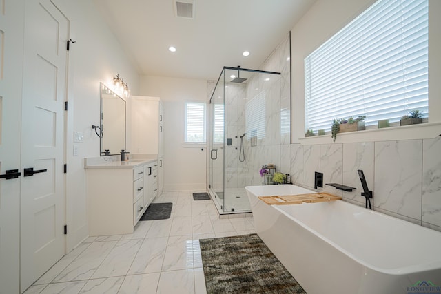 bathroom with separate shower and tub, a wealth of natural light, vanity, and tile walls