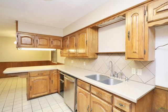 kitchen featuring kitchen peninsula, backsplash, stainless steel dishwasher, sink, and light tile patterned floors