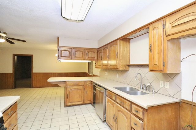 kitchen featuring sink, stainless steel dishwasher, ceiling fan, light tile patterned flooring, and kitchen peninsula