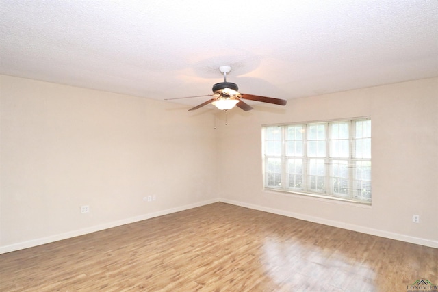 empty room with hardwood / wood-style flooring, ceiling fan, and a textured ceiling