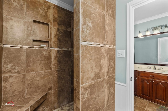 bathroom with a tile shower, vanity, and crown molding