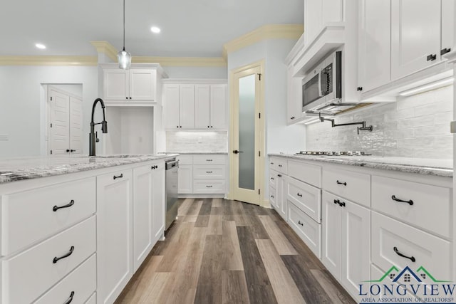 kitchen with white cabinetry, hanging light fixtures, stainless steel appliances, tasteful backsplash, and light stone counters