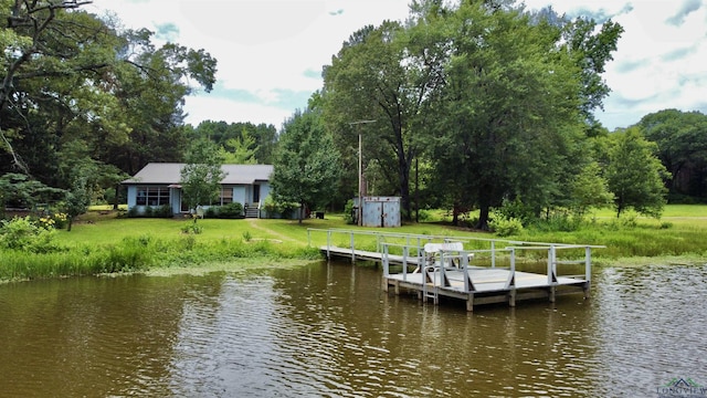 view of dock featuring a lawn and a water view