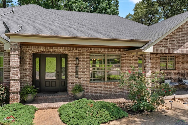 3718 Ben Hogan Dr, Longview, TX 75605 - doorway to property featuring roof with shingles and brick siding