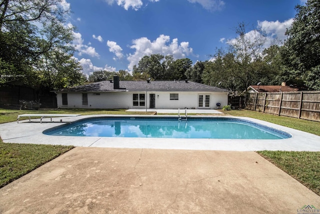 view of pool with a lawn, a diving board, and a patio area