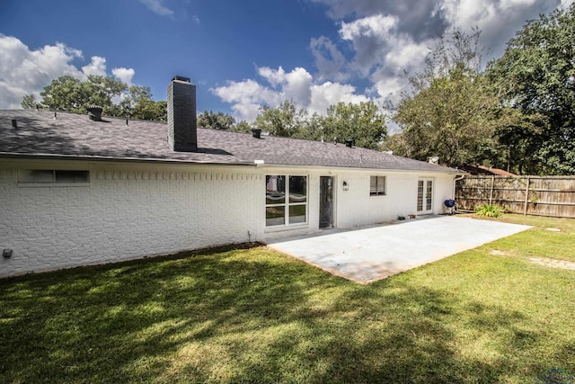 rear view of house featuring a yard and a patio