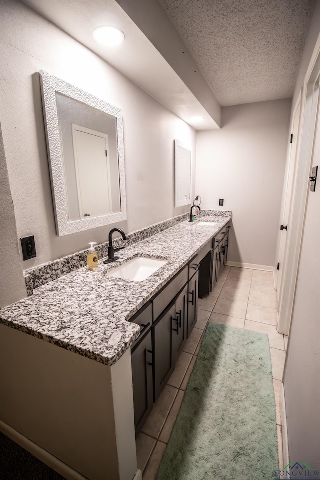 bathroom featuring tile patterned flooring, vanity, and a textured ceiling