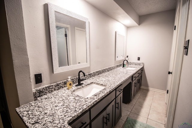 bathroom with tile patterned flooring, vanity, and a textured ceiling