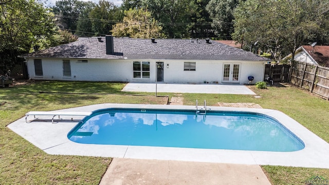 view of swimming pool featuring a diving board, a patio area, a yard, and french doors