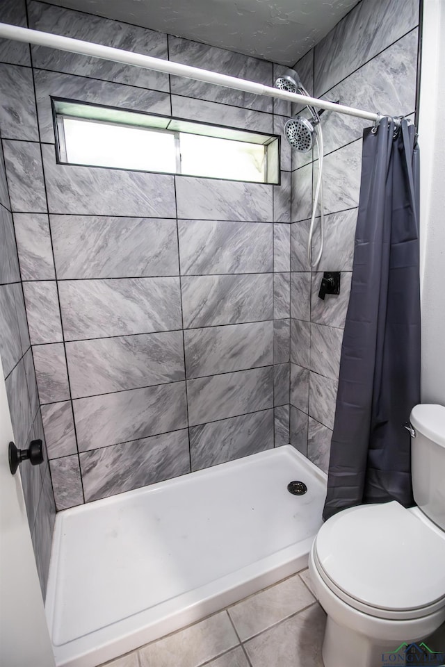 bathroom featuring tile patterned floors, curtained shower, and toilet