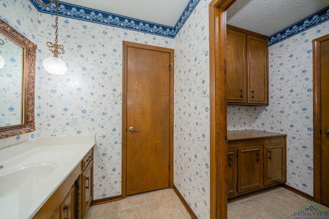 bathroom featuring tile patterned flooring, vanity, and a textured ceiling