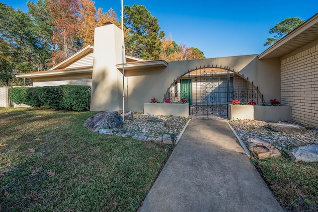 view of side of property featuring a garage and a lawn