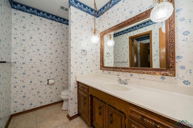 bathroom featuring tile patterned floors, vanity, and toilet