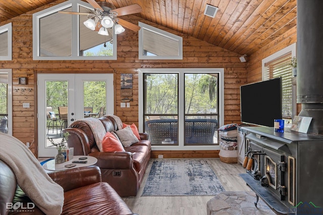 living room with a wood stove, french doors, vaulted ceiling, light wood-type flooring, and wood ceiling