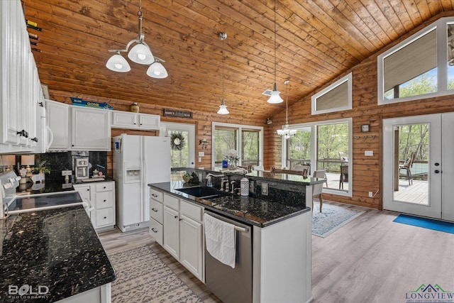 kitchen with sink, white appliances, white cabinetry, and hanging light fixtures