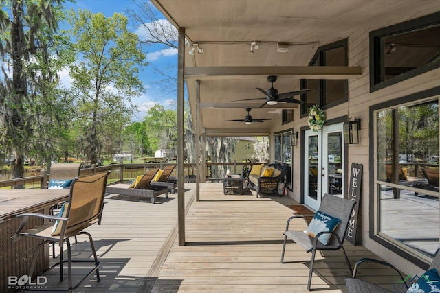 wooden terrace featuring french doors and ceiling fan