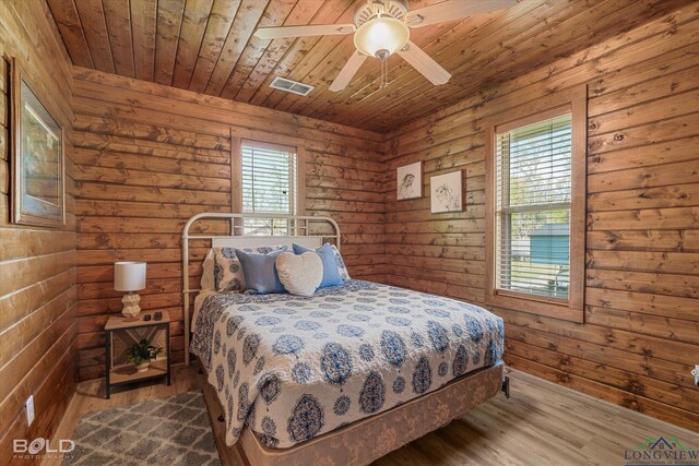 bedroom featuring hardwood / wood-style flooring, ceiling fan, wood ceiling, and multiple windows